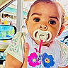 baby, bib, bow, car, car_mirror, child, clothing, colorful, curly_hair, cute, face, hand, infant, inside, pacifier, person, portrait, seat, window, young