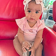 Dioř Aahmoř joined the competition — help win amazing prizes! baby, child, pink_bow, headband, pink_clothing, red_chair, leather_chair, indoors, cute, sitting, shoe, curious, infant, portrait, toddler, furniture, home, person, smile, hands