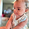adorable, baby, background_blur, child, closeup, curly_hair, cute, dress, expression, face, focus, hand, holding_hands, indoor, infant, person, portrait, skin, smiling, young_child