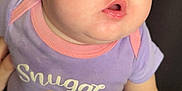 Emory is registered to the contest to win money with this photo: baby, infant, child, cute, purple_clothing, polka_dot_pants, snuggle_text, cupcake_graphic, earrings, chubby_cheeks, closeup, soft_lighting, indoor, person, portrait, young_child, curious, sitting, hand, face