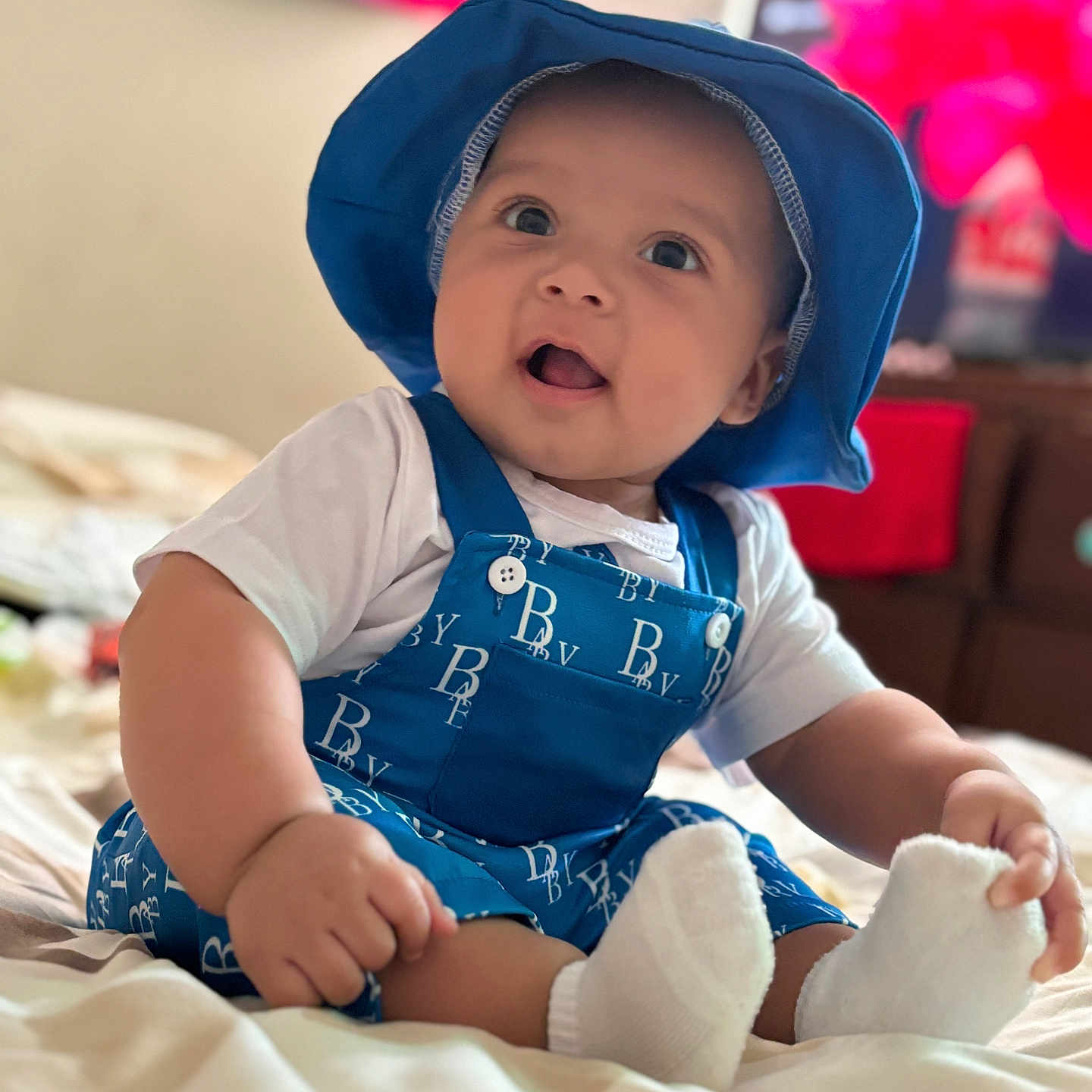 Zavian joined the competition — help win amazing prizes! baby, bodypart, bonnet, cap, clothing, face, finger, hand, happy, hat, head, hood, hosiery, person, photography, portrait, sitting, smile, sock, sunhat