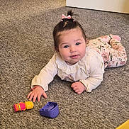Alyara is registered to the contest to win money with this photo: baby, child, infant, toy, carpet, floor, indoor, pink_bow, curly_hair, white_top, floral_pants, crawling, cute, playtime, person, young_child, smiling, hand, face, home