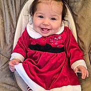 Alyara joined the competition — help win amazing prizes! baby, child, smiling, red_dress, striped_leggings, hair_bows, seated, cushion, happy, indoors, portrait, holiday_outfit, cute, face, person, infant, clothing, white_trim, pink, red