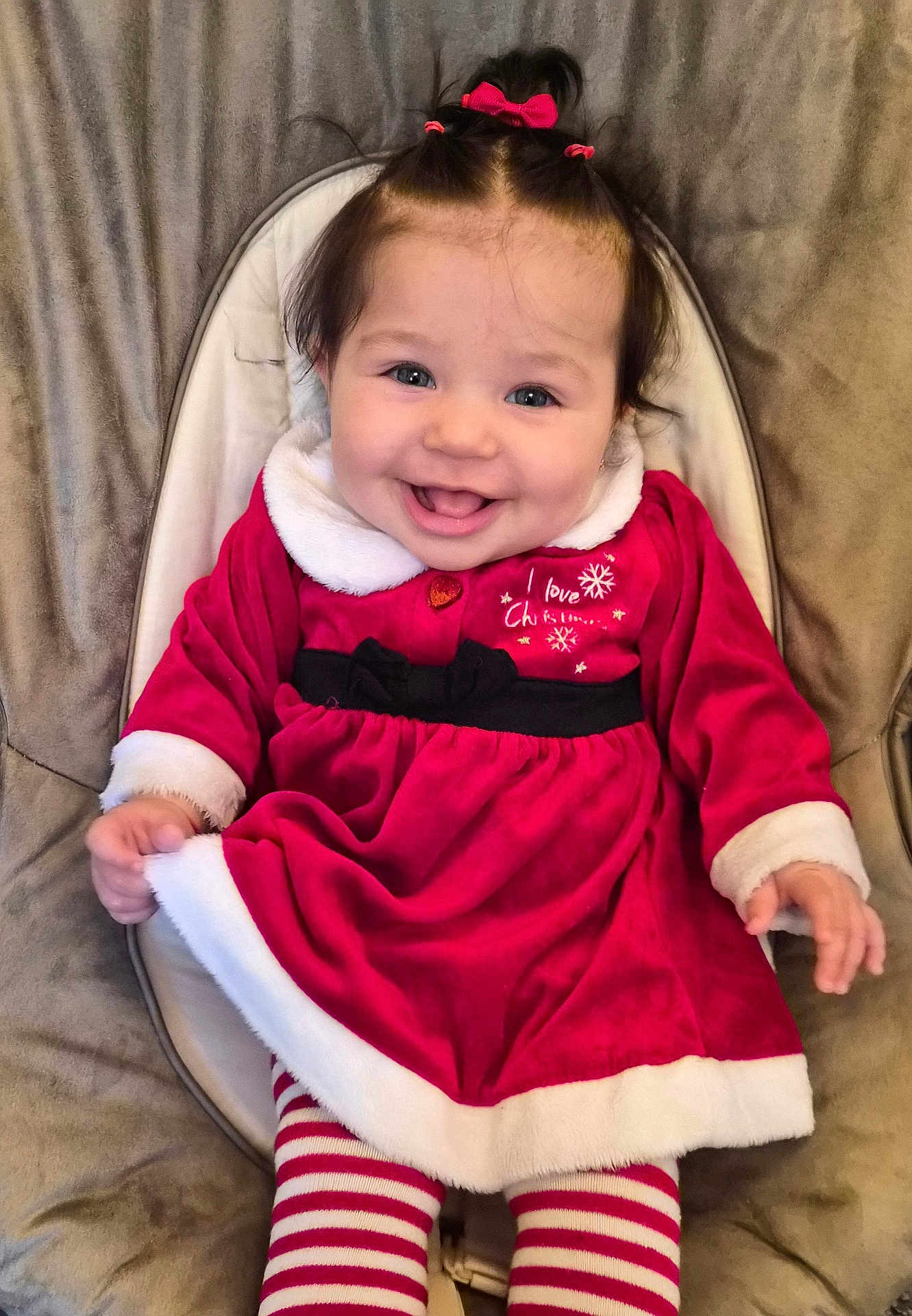 Alyara joined the competition — help win amazing prizes! baby, child, smiling, red_dress, striped_leggings, hair_bows, seated, cushion, happy, indoors, portrait, holiday_outfit, cute, face, person, infant, clothing, white_trim, pink, red