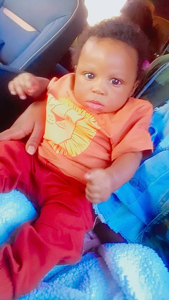 Adonis Griffin is registered to the contest to win money with this photo: azure, baby, baby_toddler_clothing, blue, child, comfort, electric_blue, finger, fun, gesture, hand, happy, mouth, nail, person, pink, product, sitting, skin, thumb