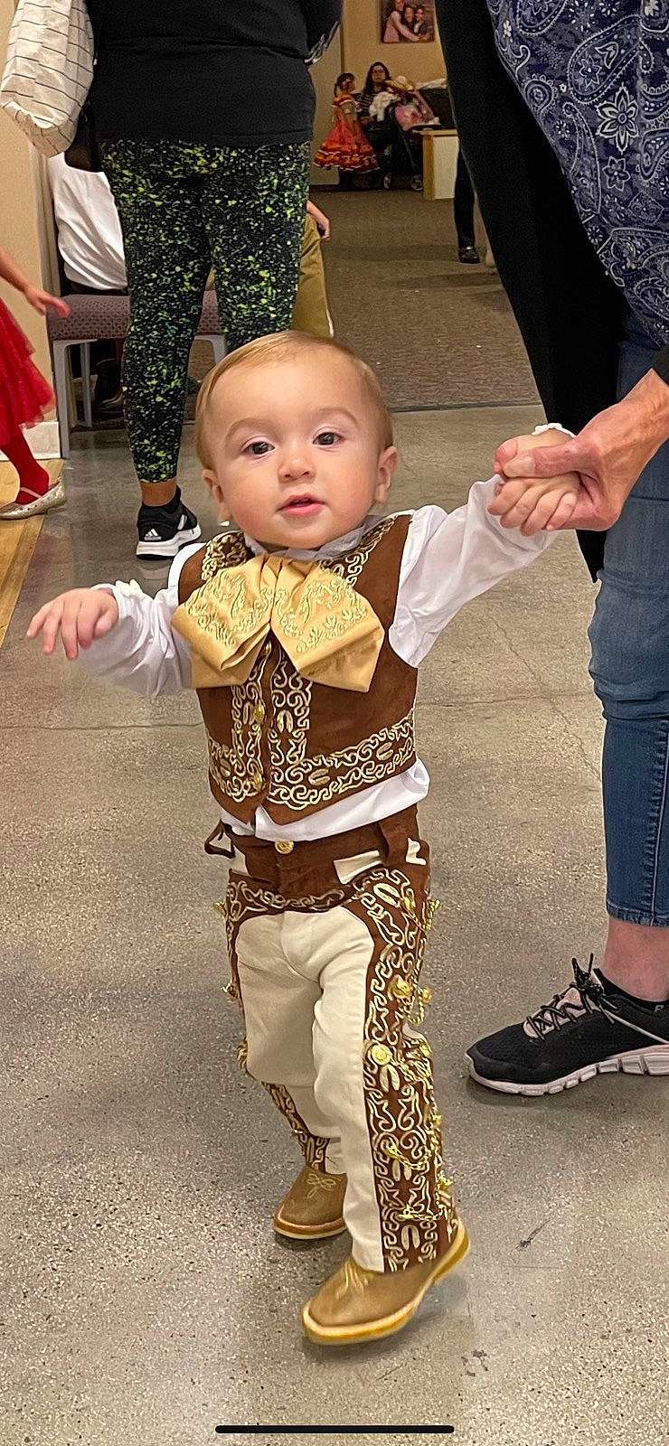Joseph is registered to the contest to win money with this photo: baby, baby_toddler_clothing, child, clothing, event, fashion_design, flooring, foot, fun, fur, gesture, happy, human_leg, person, shoe, sleeve, standing, thumb, toddler, tradition