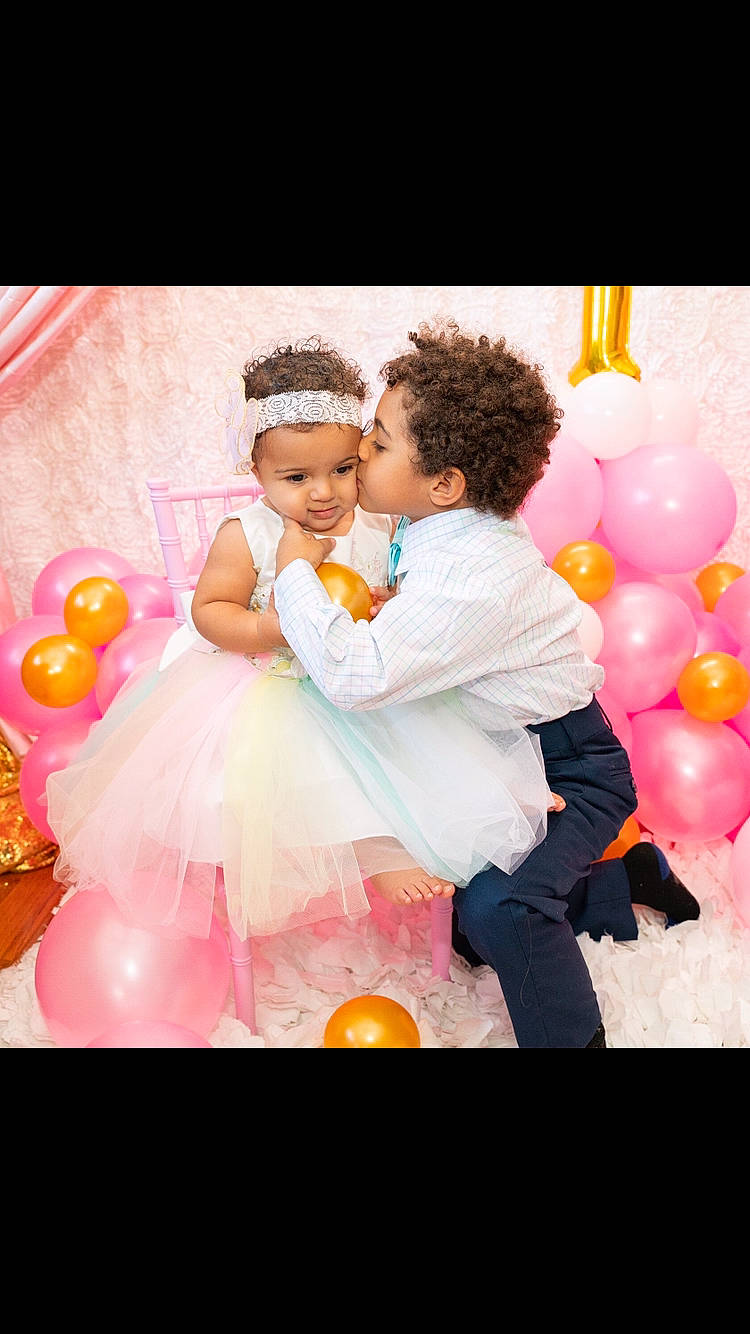 Micaela joined the competition — help win amazing prizes! baby, balloon, child, dress, event, facial_expression, flash_photography, formal_wear, friendship, fun, gesture, happy, headwear, interaction, leisure, magenta, party_supply, person, petal, photograph