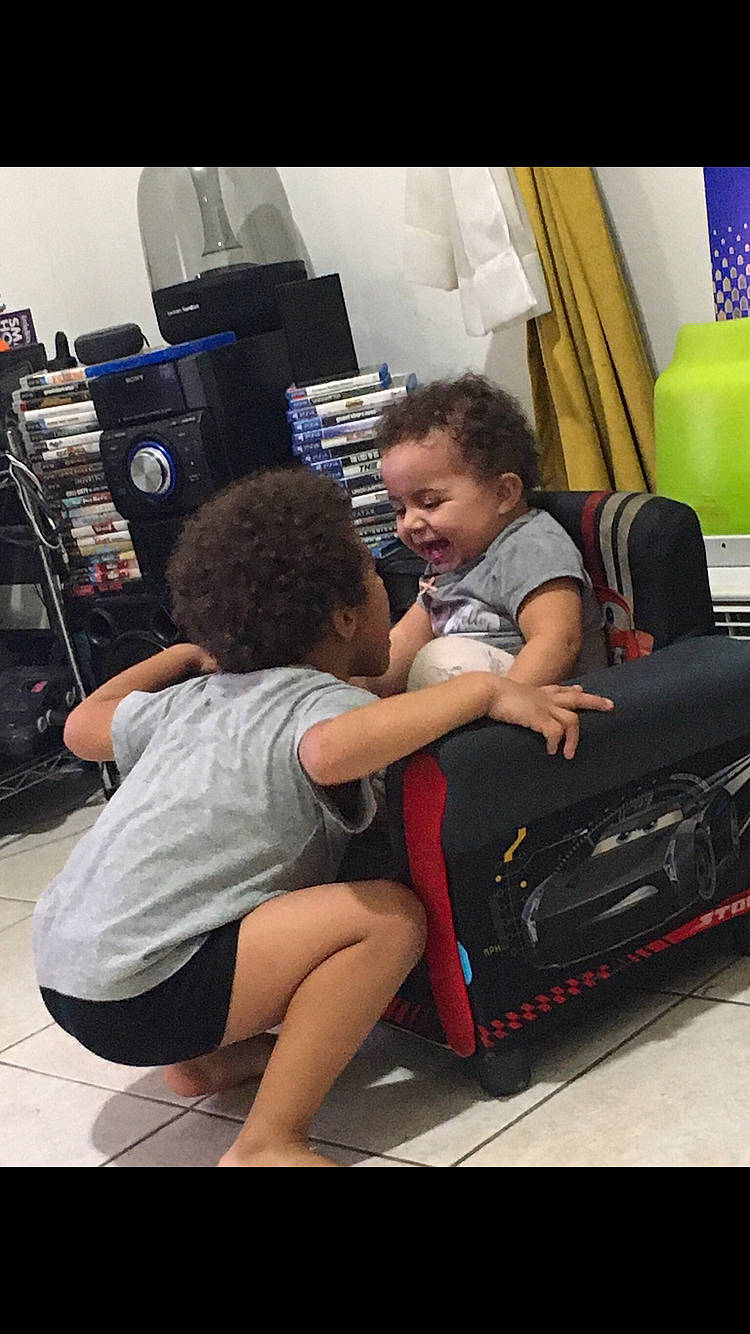 Micaela is registered to the contest to win money with this photo: automotive_design, automotive_exterior, automotive_tire, bumper, child, computer_keyboard, curtain, event, fun, hairstyle, human_leg, leisure, motor_vehicle, person, room, shorts, smile, t_shirt, thigh, tire