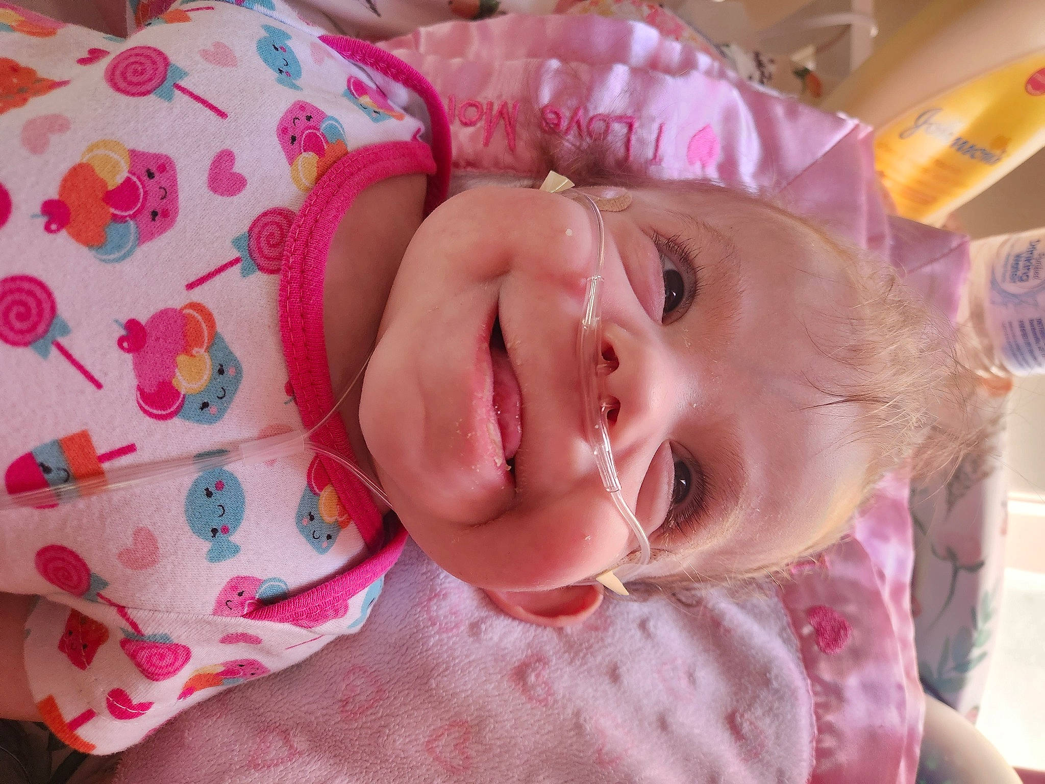 Nora is registered to the contest to win money with this photo: baby, baby_laughing, baby_toddler_clothing, cheek, child, eye, eyelash, fun, happy, head, iris, joy, lip, magenta, mouth, nose, pattern, person, pink, skin