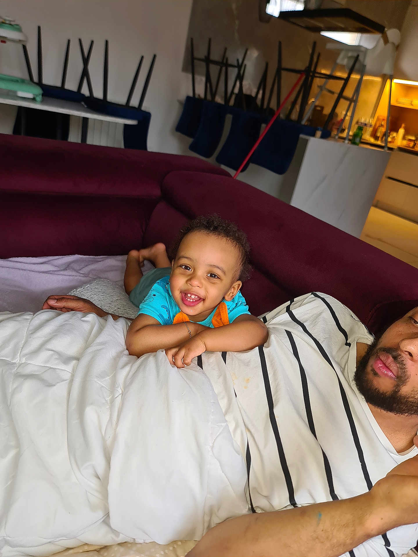 Matteo a rejoint le concours — aidez-le/la à gagner de superbes lots ! toddler, child, smiling, couch, maroon, blanket, striped_shirt, adult, living_room, kitchen, relaxing, happy, indoor, family, playful, curly_hair, person, furniture, home, casual