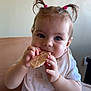 baby, child, high_chair, biscuits, pigtails, cute, eating, food, indoor, infant, person, bib, face, hand, table, light, skin, clothing, blue_eyes, happy