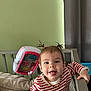 Eliana participe au concours pour gagner de l'argent avec cette photo : baby, child, crib, toy, pigtails, striped_shirt, smiling, tongue_out, nursery, furniture, playful, happy, indoors, person, infant, cute, necklace, expression, hand, home
