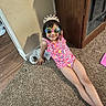 Amelia is registered to the contest to win money with this photo: child, girl, smile, swimsuit, tiara, sunglasses, carpet, indoor, shadow, cabinet, wooden, floor, playful, colorful, happy, relaxed, person, home, casual, fun