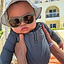 Tristan joined the competition — help win amazing prizes! baby, child, sunglasses, hat, hand, adult_hand, outdoor, sunny, resort, building, balcony, palm_tree, clothing, blue_shirt, portrait, closeup, person, summer, vacation, cute