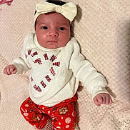 Kaylani joined the competition — help win amazing prizes! baby, infant, child, headband, bow, pajamas, holiday, christmas, candy_cane, heart, red_pants, white_sweater, blanket, soft_texture, lying_down, cute, portrait, indoors, smiling, festive