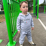 Heimdall participe au concours pour gagner de l'argent avec cette photo : child, playground, green, sportswear, hoodie, sneakers, outdoor, smile, person, park, young, casual, concrete, fence, trees, daytime, cute, standing, fun, expression