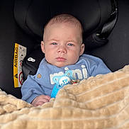 Jesse is registered to the contest to win money with this photo: baby, infant, car_seat, blanket, pacifier, blue_clothing, face, head, person, child, indoor, seatbelt, safety, cute, expression, human, newborn, soft_texture, warm, comfort
