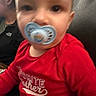 adult, baby, casual_clothing, child, close_up, couch, eyes, face, family, front_facing, head, home, indoors, infant, pacifier, photograph, portrait, red_shirt, sitting, toddler
