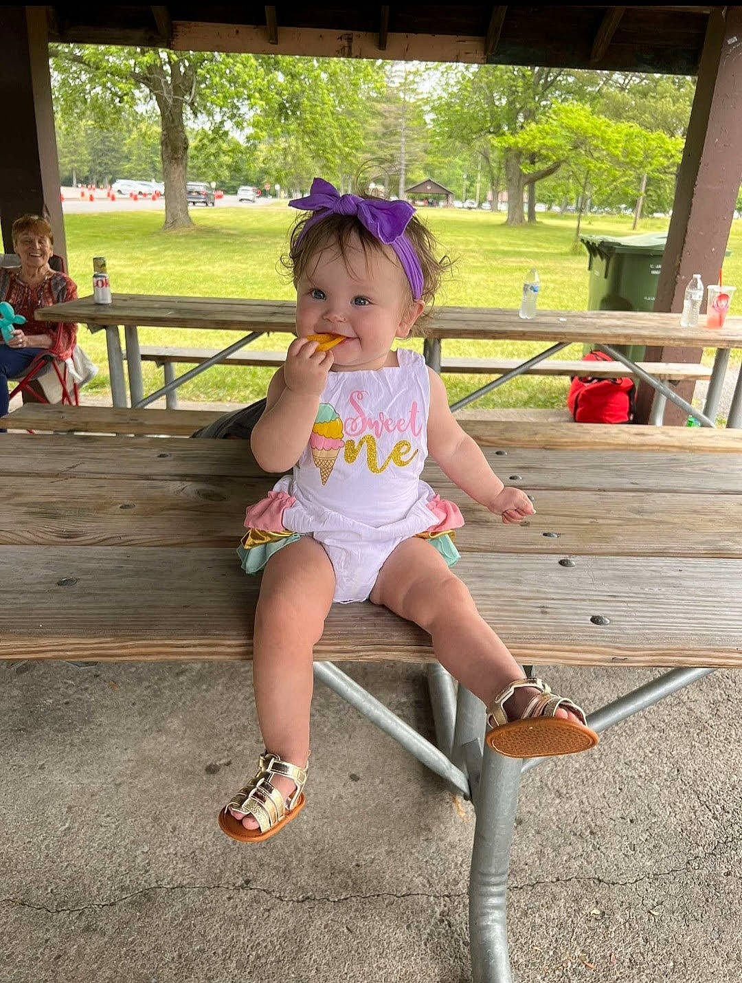 Harleigh is registered to the contest to win money with this photo: baby_toddler_clothing, child, fun, grass, happy, hat, human_leg, joy, knee, leisure, outdoor_furniture, person, plant, public_space, recreation, sandal, shorts, sitting, summer, thigh