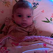 Willow joined the competition — help win amazing prizes! baby, blanket, cushion, floral_pattern, heart_pattern, wooden_wall, portrait, face, child, indoor, curly_hair, photography, soft_lighting, cozy, cute, expression, person, fabric, bedroom, decor