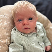 Jacob participe au concours pour gagner de l'argent avec cette photo : baby, infant, face, blue_eyes, blonde_hair, striped_shirt, cushion, pattern, animal_print, close_up, portrait, child, soft_light, indoor, curious, young, person, skin, expression, seated