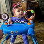 Alaina is registered to the contest to win money with this photo: baby, child, headband, pink_bow, walker, toy, blue, purple_clothing, white_shoes, carpet, indoor, cabinet, curious, expression, person, infant, playful, furniture, cute, home