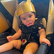 Alaina joined the competition — help win amazing prizes! baby, child, car_seat, pacifier, crown, seat_belt, black_clothing, indoor, cute, infant, sitting, strapped, looking, face, headwear, young_child, adorable, safety, people, portrait