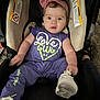 Alaina joined the competition — help win amazing prizes! baby, child, car_seat, purple_clothing, headband, pink_bow, shoe, infant, cute, sitting, indoors, car_seat_warning_labels, footwear, person, young_child, apparel, headwear, expression, holding, carpet