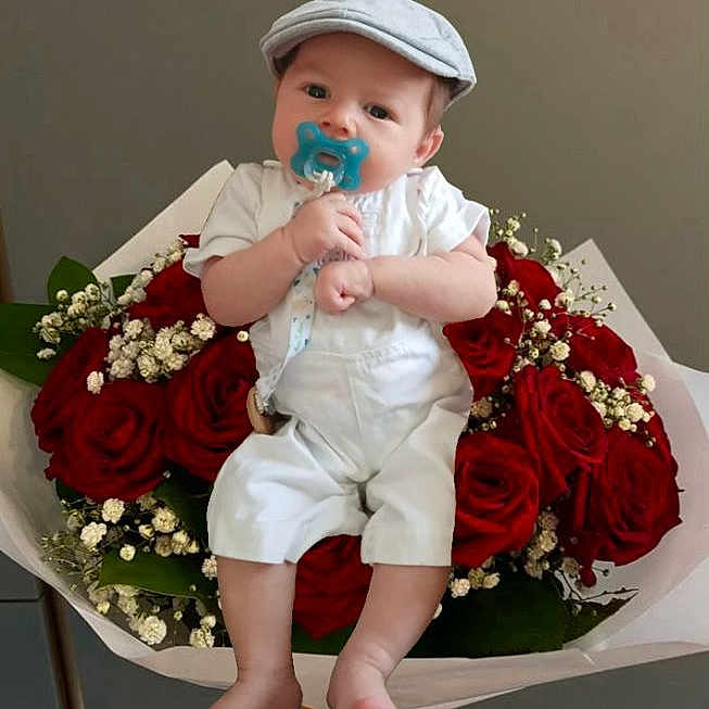 Gabriel participe au concours pour gagner de l'argent avec cette photo : baby, bouquet, bracelet, cap, child, cute, flower_arrangement, flowers, green_leaves, hand, indoor, infant, neutral_background, pacifier, portrait, red_roses, roses, sitting, soft_lighting, white_overalls
