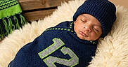 A'Mere is registered to the contest to win money with this photo: baby, beanie, blanket, cozy, cushion, helmet, indoor, infant, knitwear, number_12, peaceful, portrait, resting, scarf, seattle_seahawks, sleeping, soft, sports, swaddled, wooden_crate