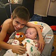 Alek joined the competition — help win amazing prizes! child, baby, smile, blanket, plush_toy, rudolph, indoor, holiday, christmas, couch, furniture, person, arm, wooden_floor, face, happy, sitting, cozy, infant, family