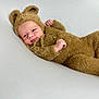 baby, infant, costume, bear, fuzzy, cute, child, smile, face, lying_down, soft_surface, portrait, cozy, adorable, animal_ears, one_person, indoors, cute_outfit, baby_clothing, closeup