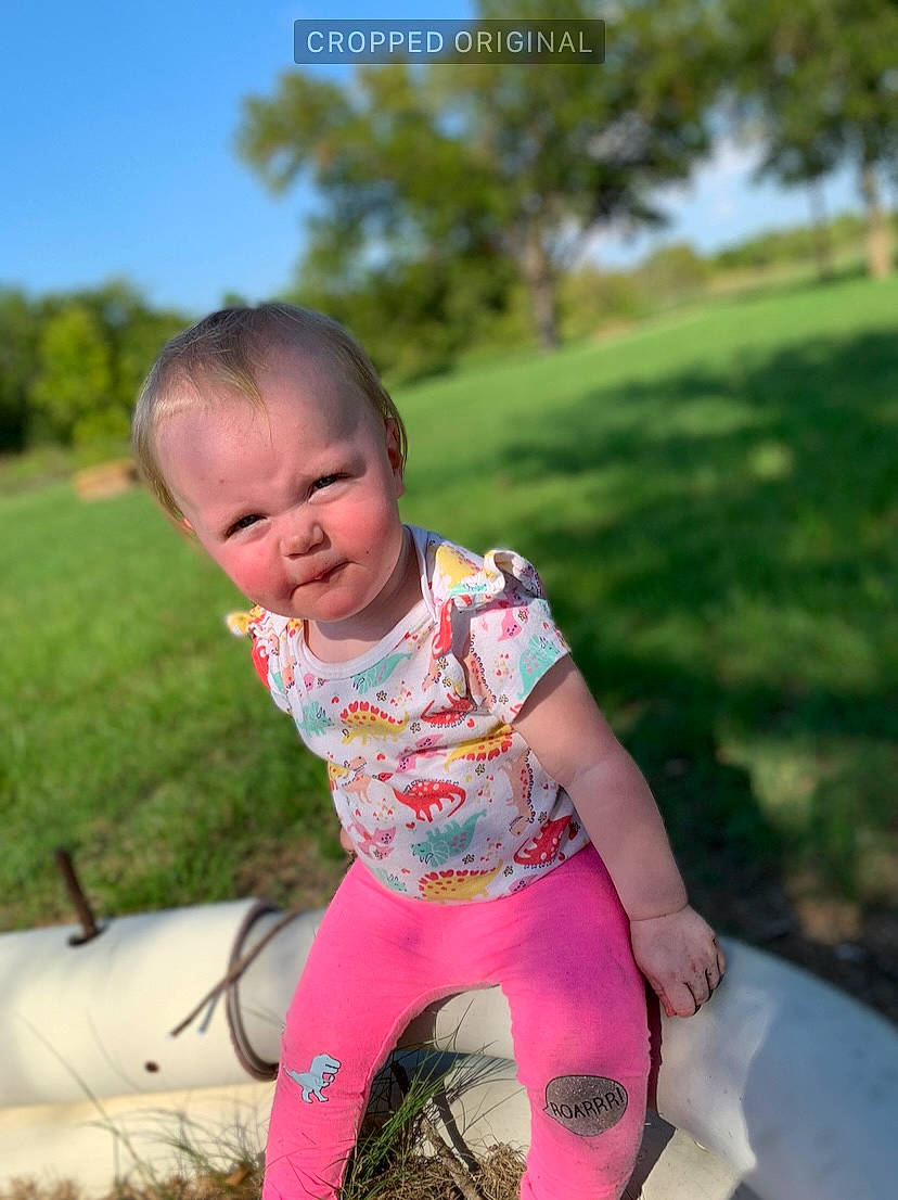 Raelynn is registered to the contest to win money with this photo: baby, baby_toddler_clothing, child, fun, grass, grassland, happy, lawn, leisure, magenta, people_in_nature, person, pink, plant, play, recreation, sitting, sky, t_shirt, toddler