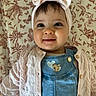 baby, infant, child, smile, headband, bow, pink, cardigan, knitwear, denim, overalls, heart_patches, face, eyes, cute, floral_pattern, blanket, portrait, indoors, happy