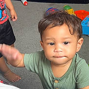 Zalen joined the competition — help win amazing prizes! toddler, child, indoor, carpet, toy, furniture, shirt, barefoot, person, spiderman, green_shirt, shelf, play, curious, expression, young_child, candid, home, kids, room