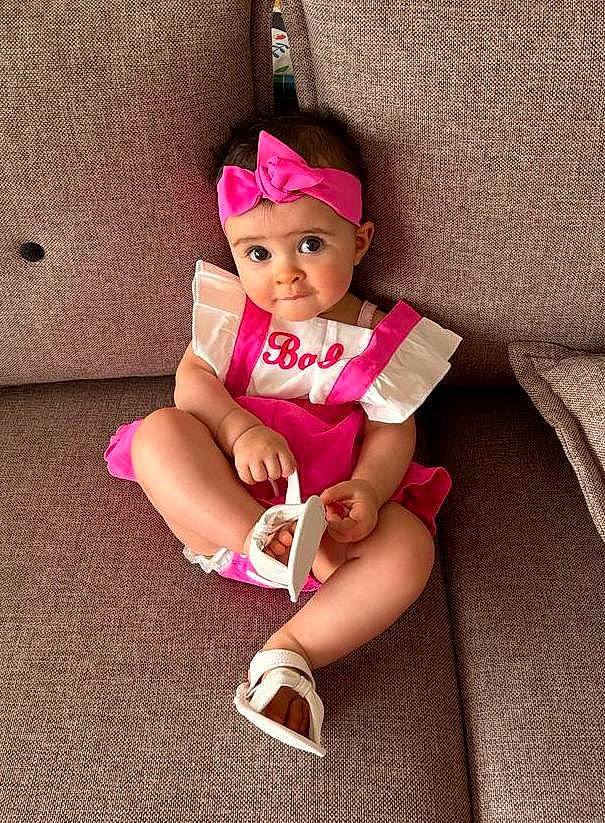 Lily participe au concours pour gagner de l'argent avec cette photo : baby_toddler_clothing, cap, child, eye, happy, hat, headgear, headwear, human_body, human_leg, knee, lap, leg, magenta, person, pink, sandal, shoe, sleeve, sock