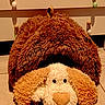 Abricot a rejoint le concours — aidez-le/la à gagner de superbes lots ! stuffed_animal, toy_dog, plush_toy, dog, furry, brown, floppy_ears, black_eyes, large_nose, indoor, floor, tile, furniture, decorations, hanging_ornaments, home_decor, cozy, closeup, portrait, pacifier