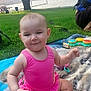 Madison is registered to the contest to win money with this photo: baby, child, pink_clothing, blanket, grass, tree, outdoor, lake, toy, sippy_cup, picnic, park, nature, smiling, cute, sitting, summer, sunlight, water, relaxation