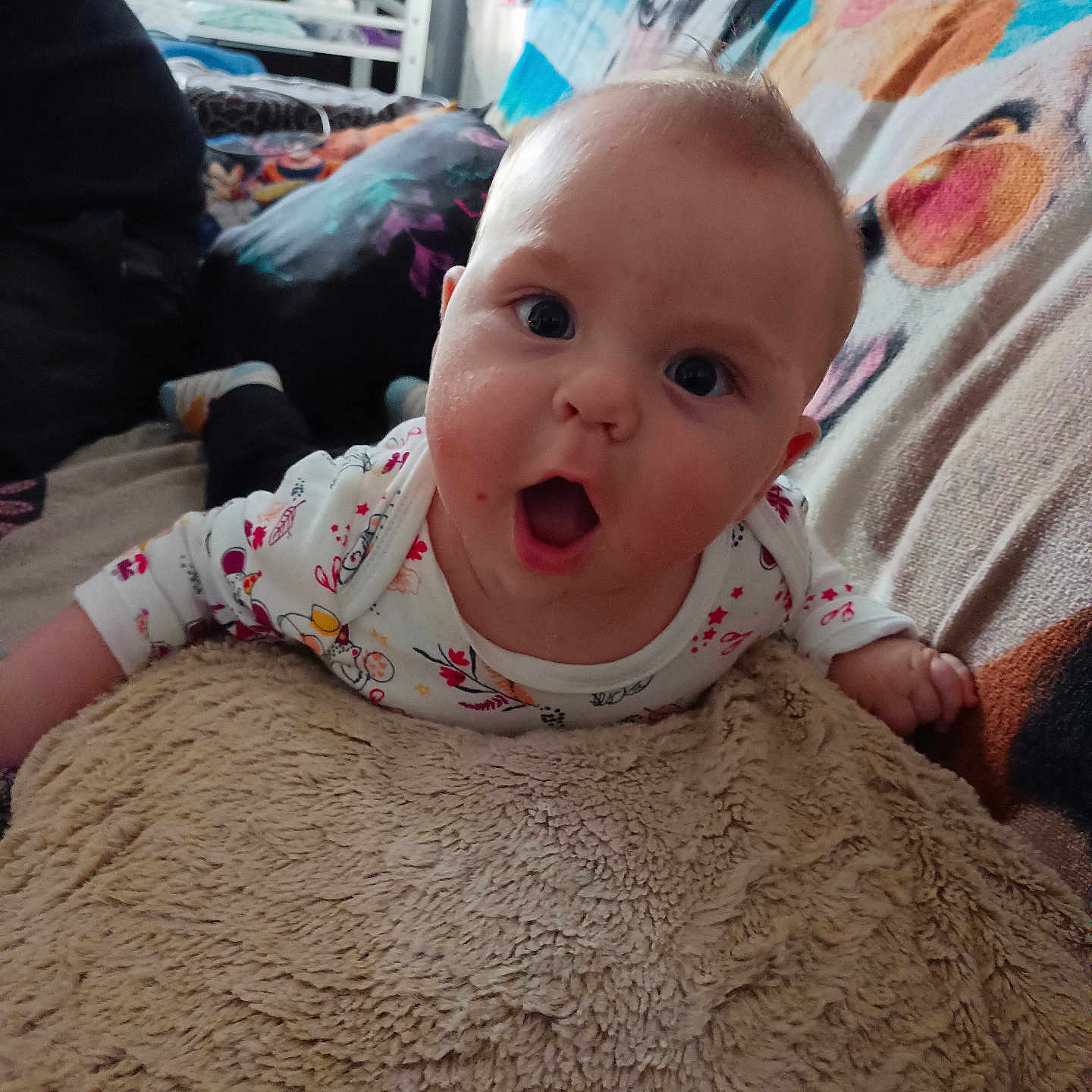 Johann a rejoint le concours — aidez-le/la à gagner de superbes lots ! baby, background, blanket, child, clothing, colorful, couch, expression, face, furniture, hand, head, home, indoor, infant, mouth_open, person, pillow, soft_texture, wide_eyes