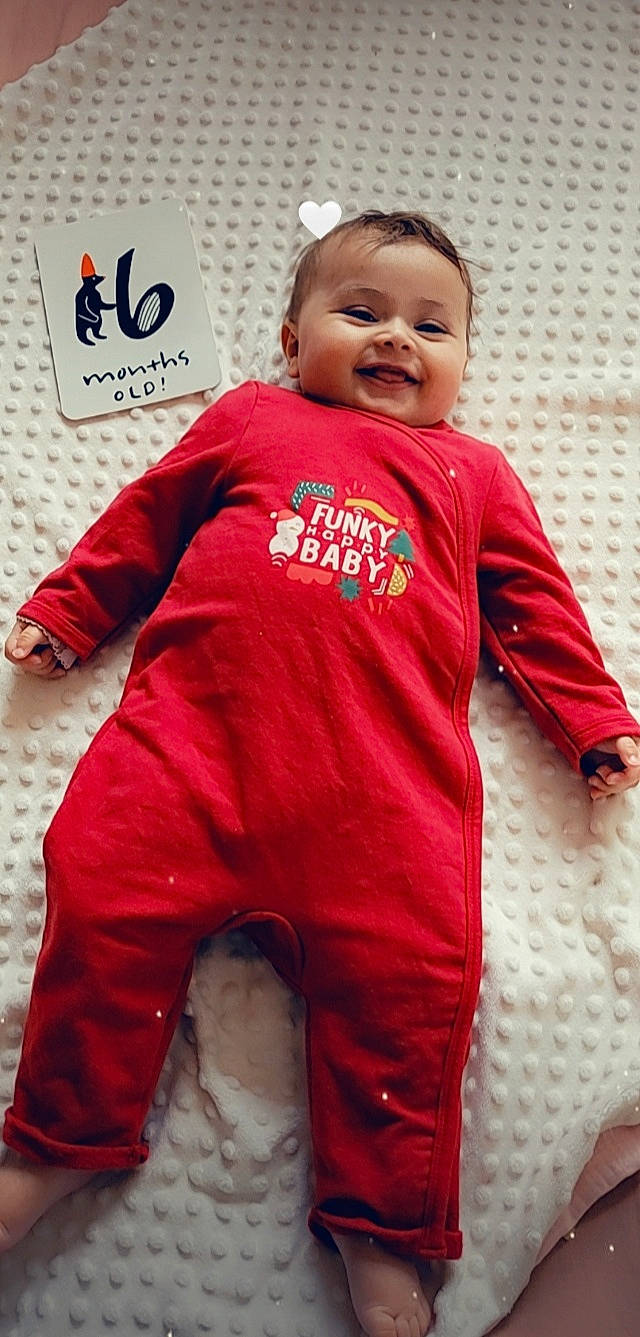 Layna a rejoint le concours — aidez-le/la à gagner de superbes lots ! baby, baby_toddler_clothing, child, eye, face, flooring, fun, happy, head, jersey, joy, neck, person, pink, red, shoulder, skin, sleeve, smile, sportswear
