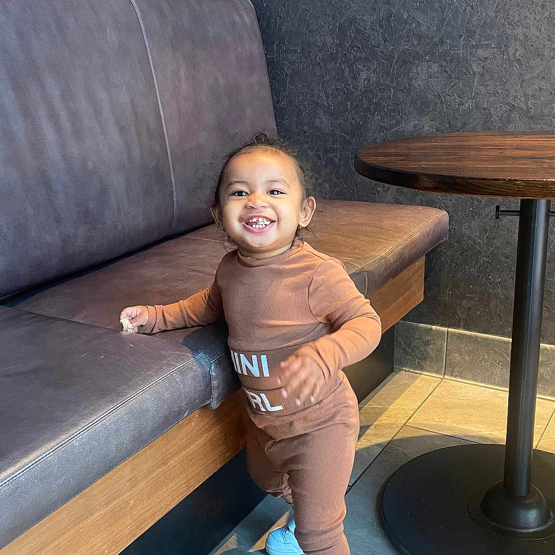 Amara joined the competition — help win amazing prizes! baby, babylaughing, boy, child, clothing, coffeetable, face, furniture, happy, head, jeans, male, pants, person, photography, portrait, sitting, sleeve, standing, table