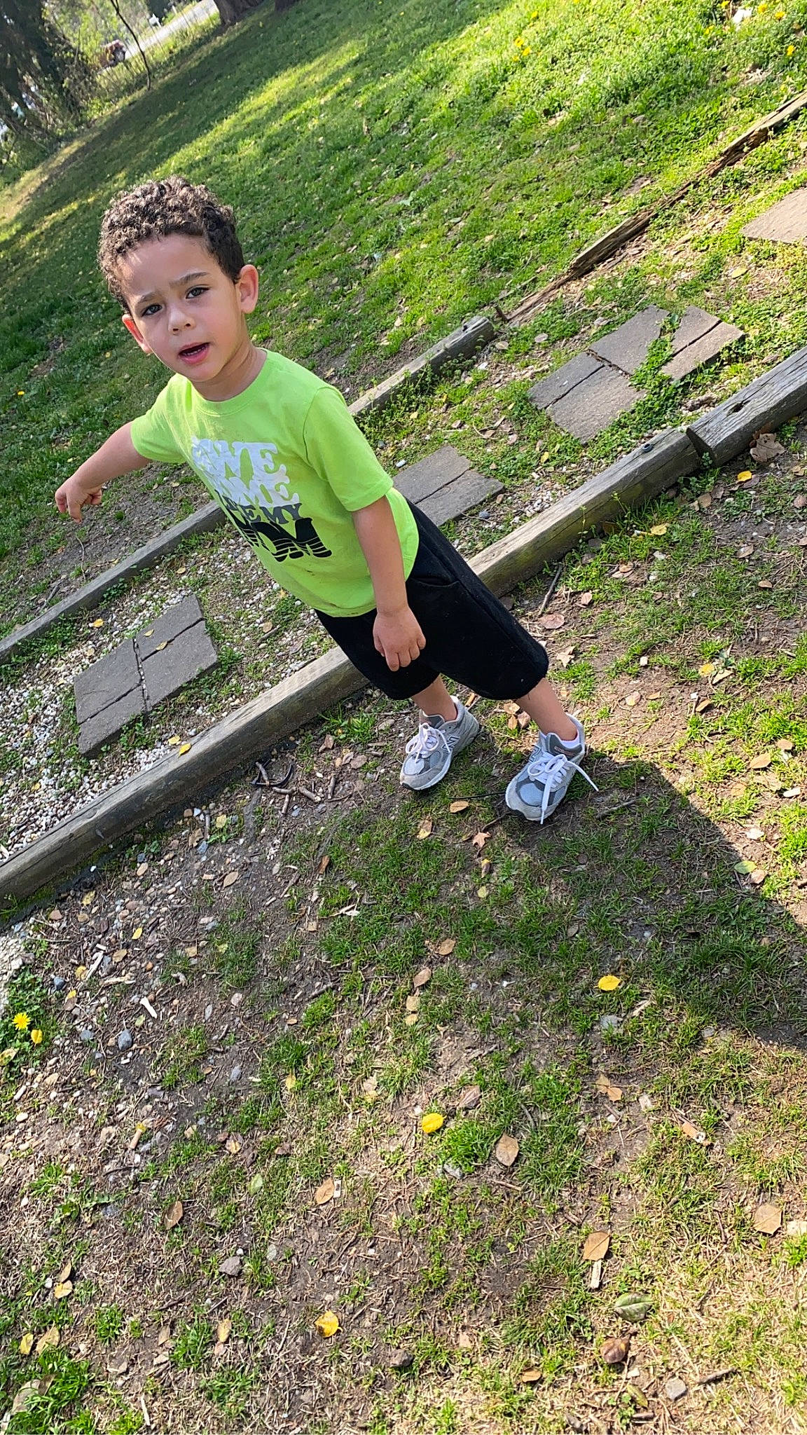 Gabriel is registered to the contest to win money with this photo: balance, child, city, fun, grass, happy, human_leg, landscape, lawn, leg, leisure, outdoor_play_equipment, people_in_nature, person, plant, recreation, shorts, sitting, soil, t_shirt