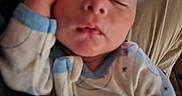 Howard is registered to the contest to win money with this photo: baby, child, closeup, cozy, cute, face, hand, indoor, infant, nap, pajamas, patterned_clothing, peaceful, person, relaxation, resting, skin, sleeping, soft_lighting, young