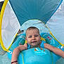 baby, child, swim_ring, water, pool, floating, smiling, sunshade, blue, inflatable, summer, outdoor, recreation, fun, person, arm, wristband, splash, cute, happy