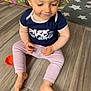 baby, barefoot, child, clothing, cute, floor, home, indoor, looking_down, pants, person, play_mat, rug, shirt, short_hair, sitting, smile, toddler, wooden_floor, young