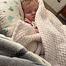 Liliana is registered to the contest to win money with this photo: baby, infant, sleeping, nap, blanket, fluffy_blanket, pillow, cozy, indoors, bedroom, portrait, peaceful, resting, face, closed_eyes, brown_hair, infant_clothing, soft_texture, home, snuggled