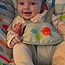 baby, baby_seat, child, clothing, colorful, comfort, cute, face, footwear, happy, indoors, infant, monkey_print, pacifier, pale_skin, person, playful, safety_harness, seated, smiling
