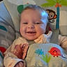 animal_print, baby, baby_seat, bird, child, clothing, couch, cushions, cute, happy, indoor, infant, living_room, monkey, person, portrait, sitting, smiling, straps, young