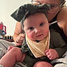 Liliana is registered to the contest to win money with this photo: baby, infant, adult, portrait, indoor, sitting, blanket, bib, headband, bow, clothing, glasses, smiling, face, blue_eyes, family, cuddling, home, soft_blanket, photography