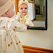 Florence joined the competition — help win amazing prizes! baby, child, girl, mirror, reflection, headband, dress, curious, indoor, carpet, wooden_trim, wall, hand, face, portrait, clothing, home, soft_light, cute, infant